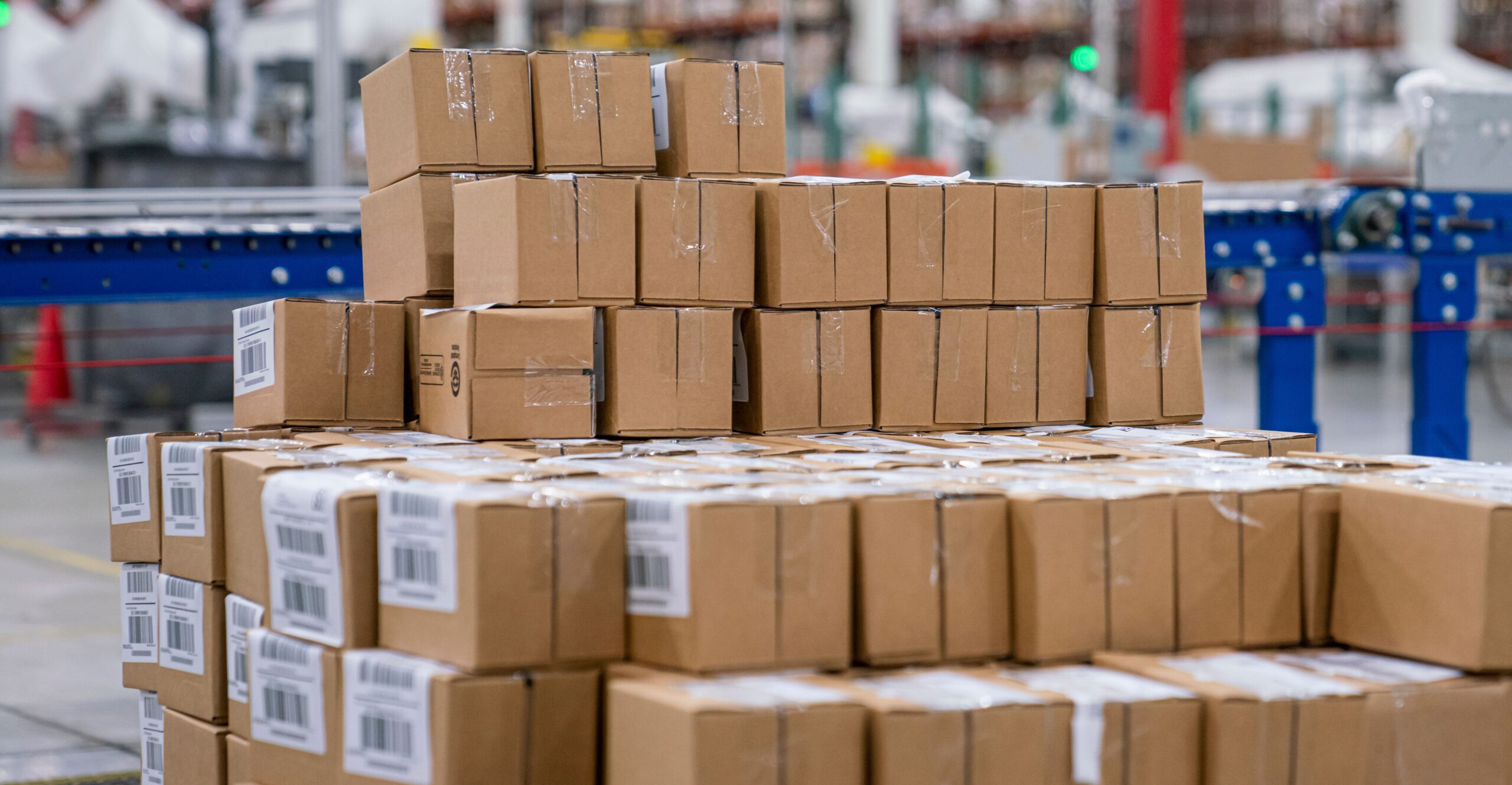 Gestapelde kartonnen dozen met verzendetiketten op een pallet in een magazijn